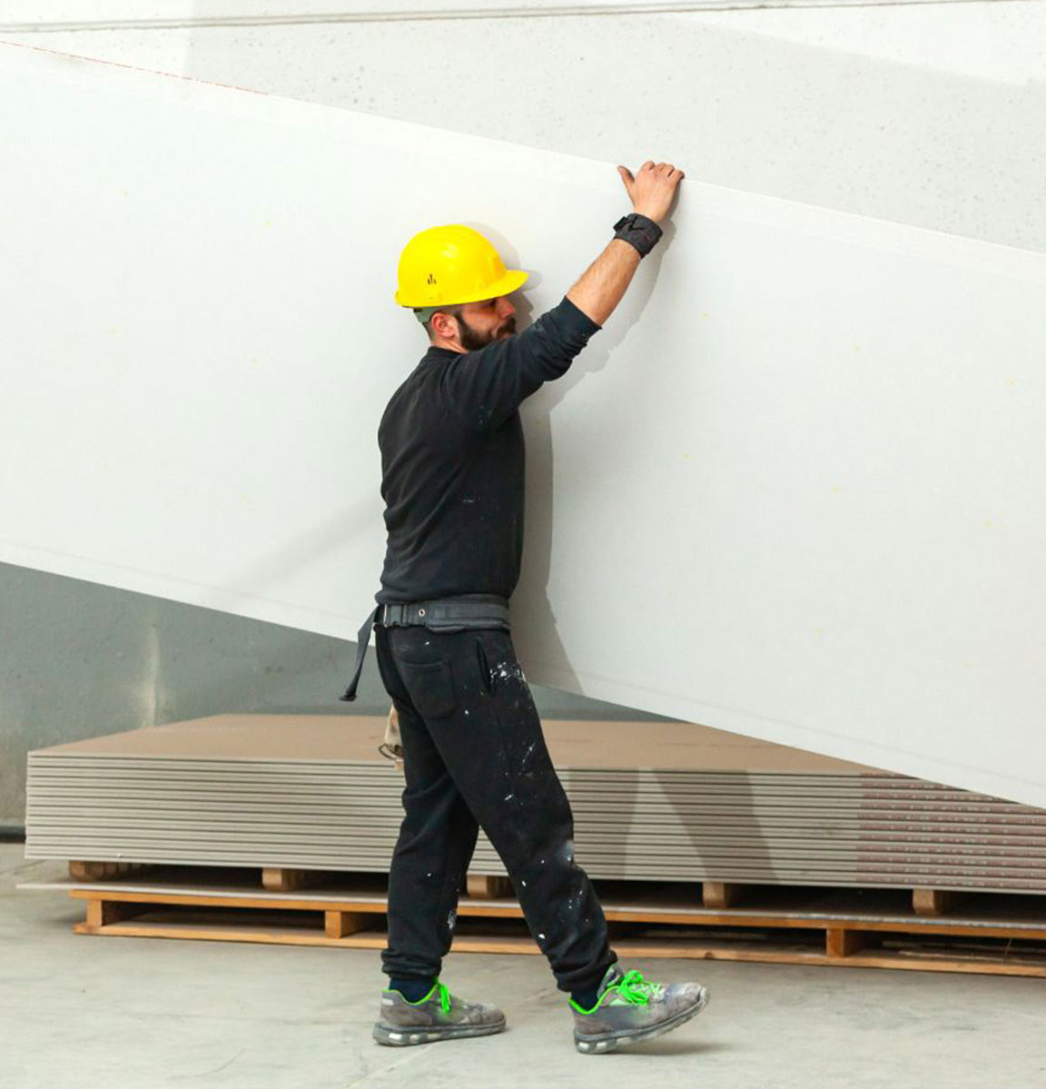 builder holding plasterboard